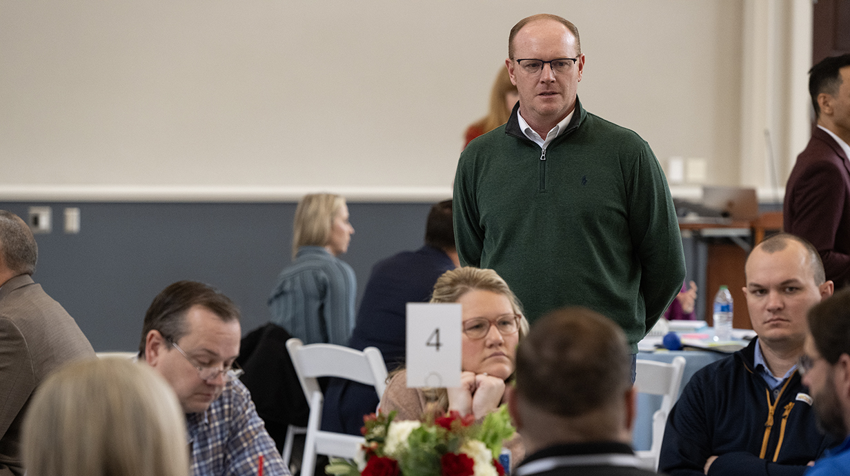 A man speaks to a group of teachers.