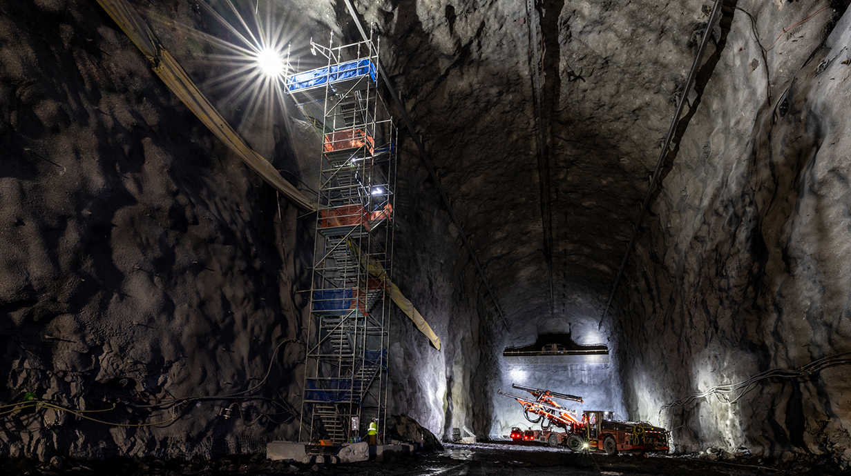Photo of a large cavern with heavy machinery working in the background.