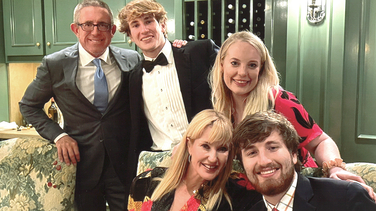 A family dressed in formalwear poses for a photo