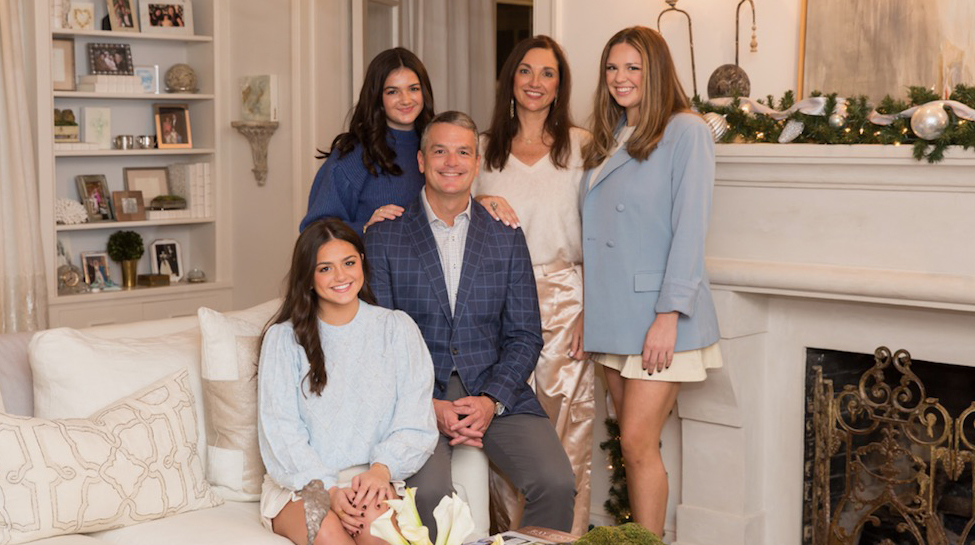 A family sits for a portrait in their living room.