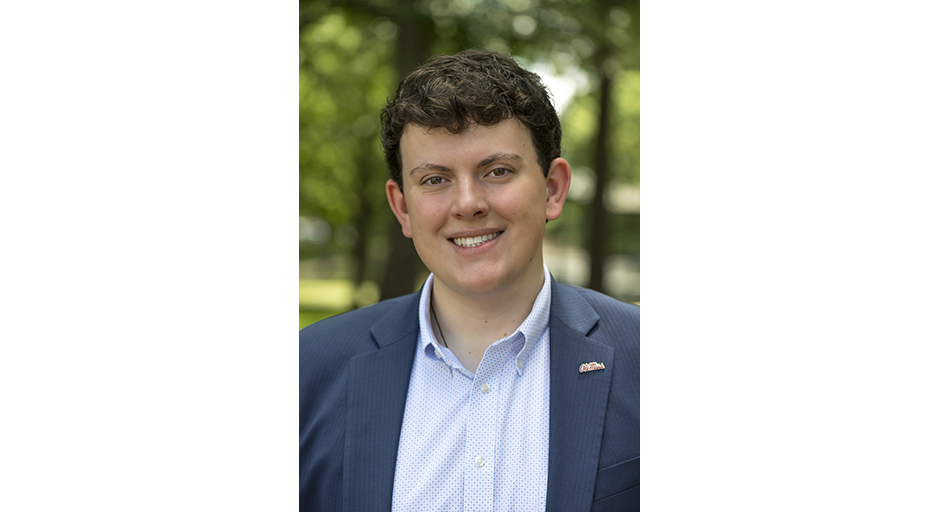 Portrait of a young man wearing a blue sportcoat.