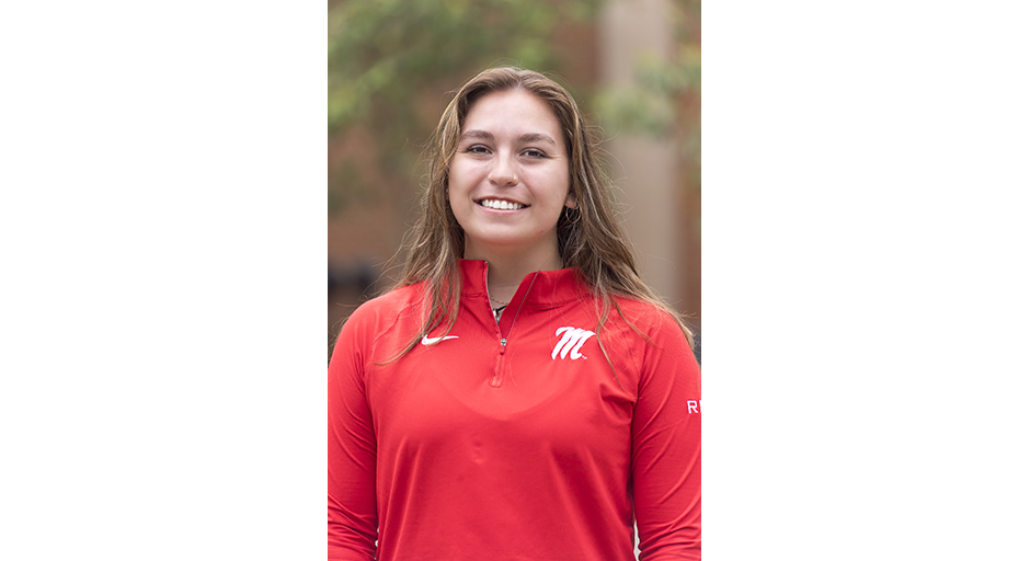 Outdoor portrait of a young woman in a red shirt.