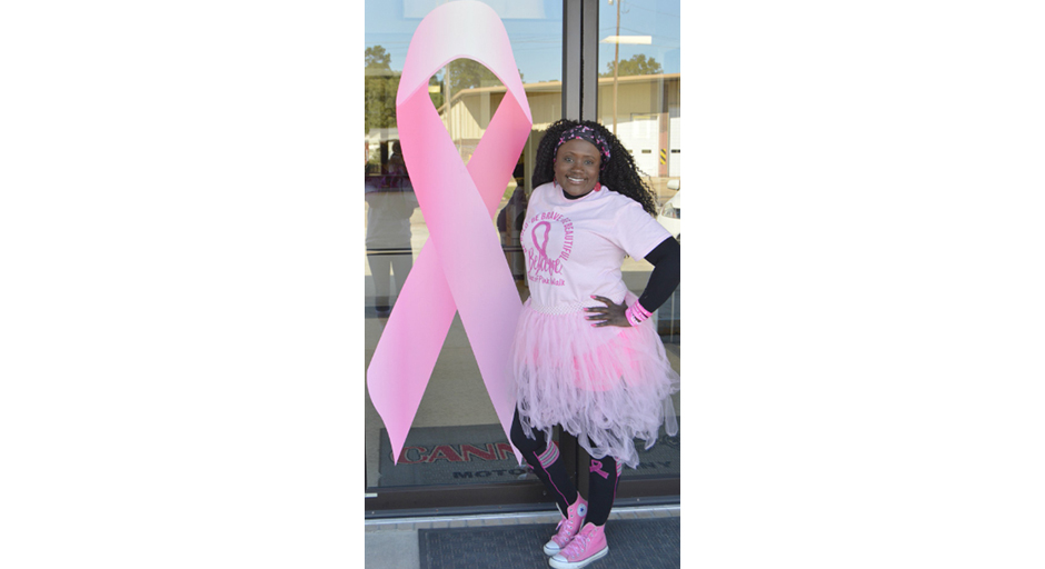 A woman poses for a photo in a frilly pink costume.