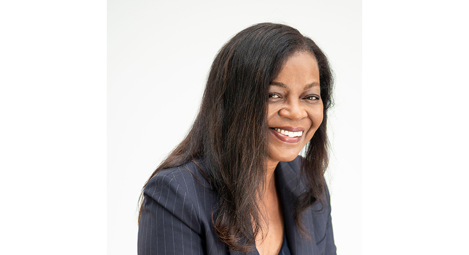 Portrait of a grinning woman wearing a dark top.