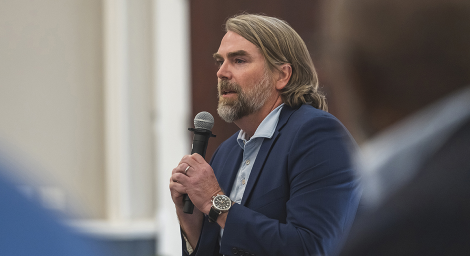 A man speaks as part of a panel discussion.