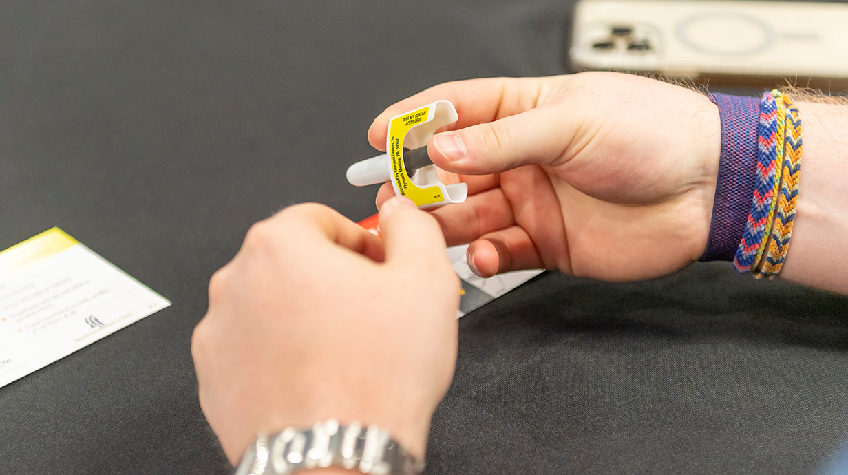 A woman's hands hold a dispenser of naloxone.