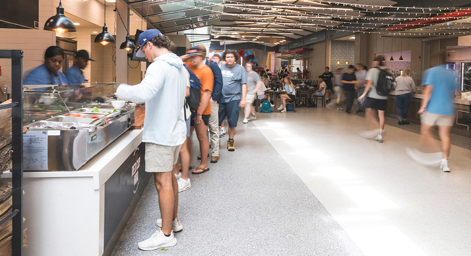 Students line up at a cafeteria station for lunch.