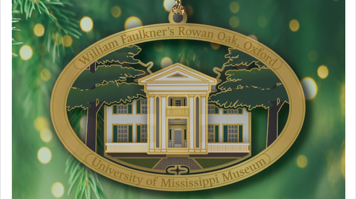 Photo of a Christmas ornament featuring the front of an elegant Southern home with white columns.