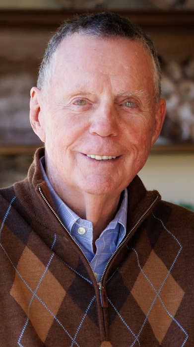 Headshot of a man wearing a brown argyle sweater.