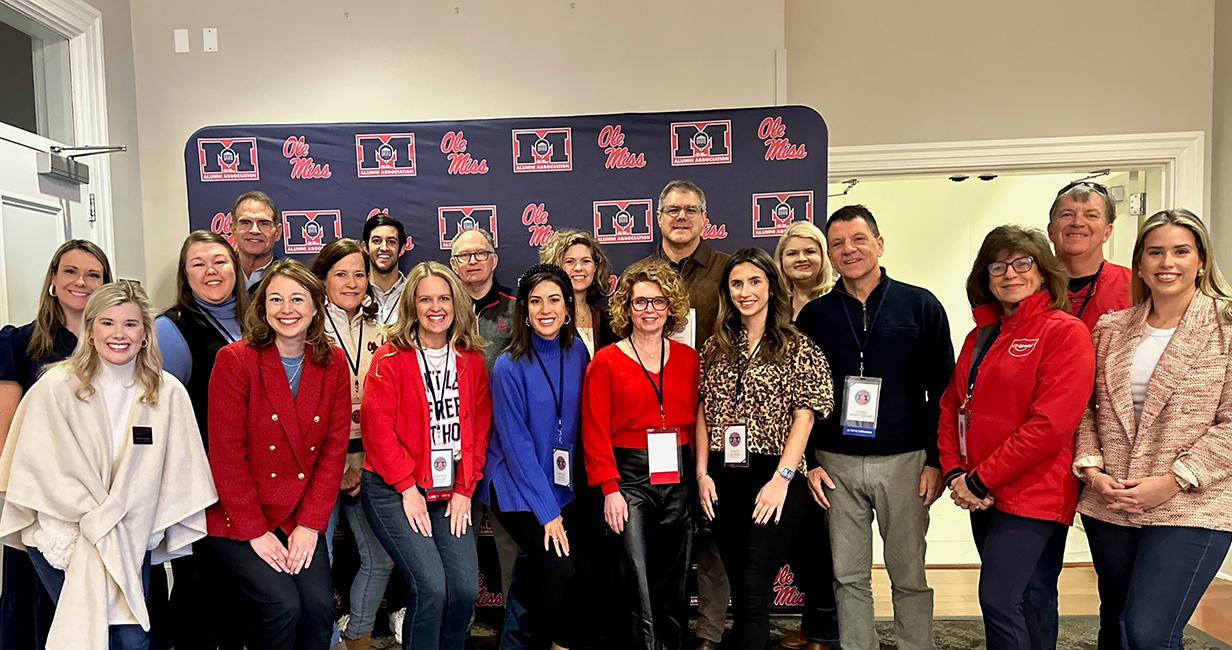 A large group of people poses for a photo in a hallway.