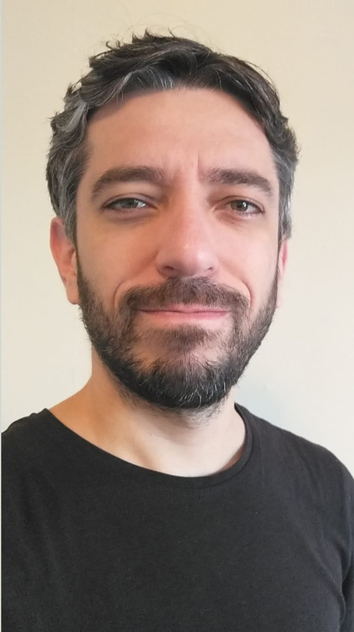 Headshot of a man wearing a black T-shirt.