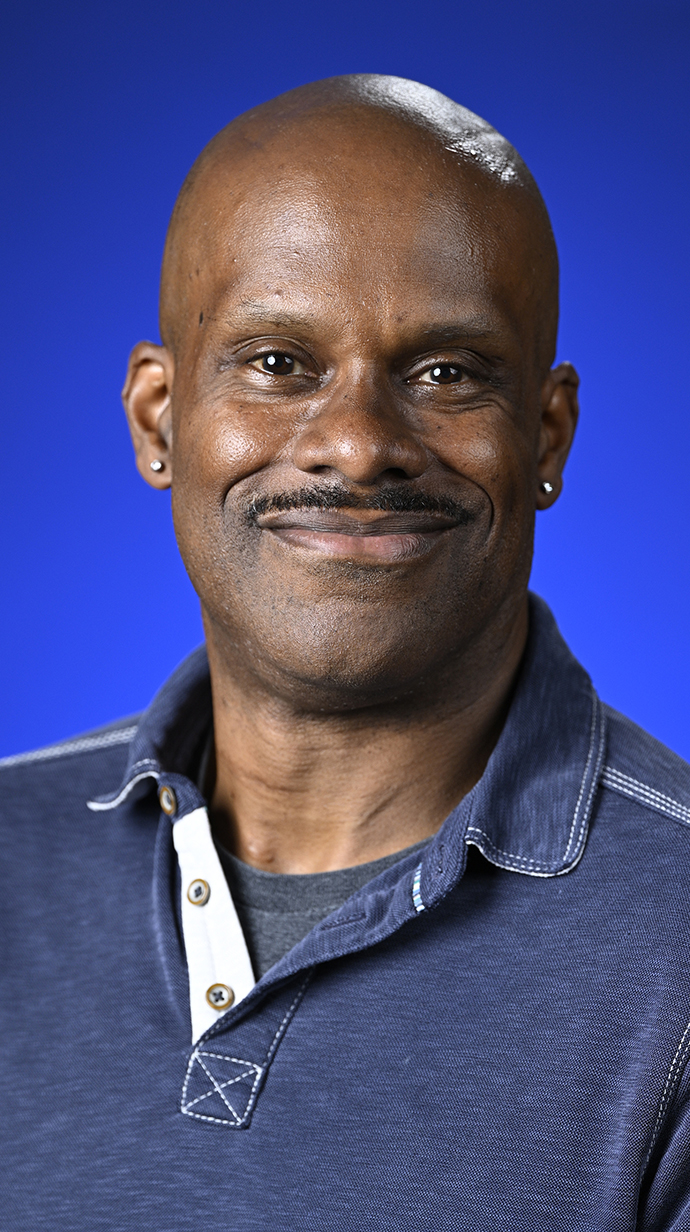 Headshot of a man wearing a casual blue shirt.