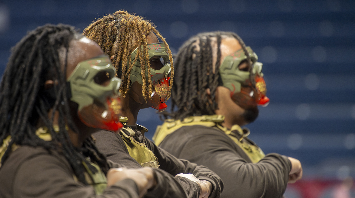 A group of young men wear masks during a ceremony.