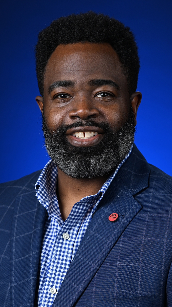Headshot of a man wearing a blue jacket and shirt.