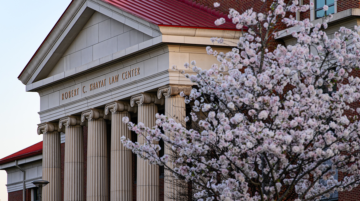 A large brick building has white columns on its facade.