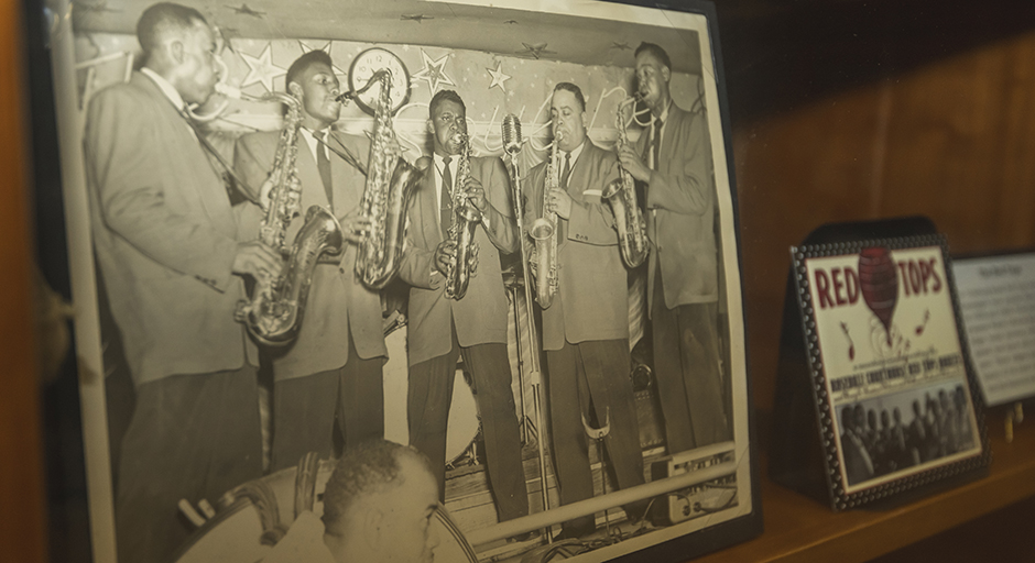 A photograph of five men playing saxophones sits on a display shelf.