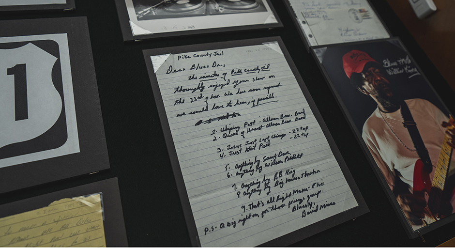 A display case holds photographs and handwritten letters.