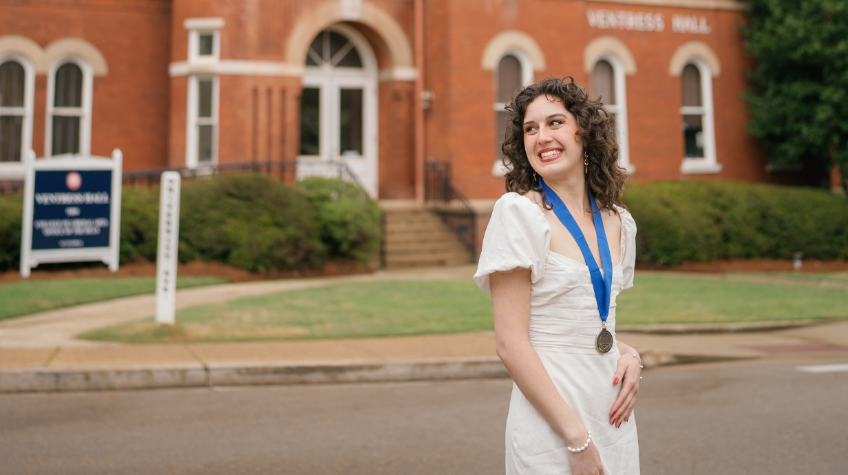 An image of Izzy Arthurs with her Taylor Medal in front of Ventress Hall