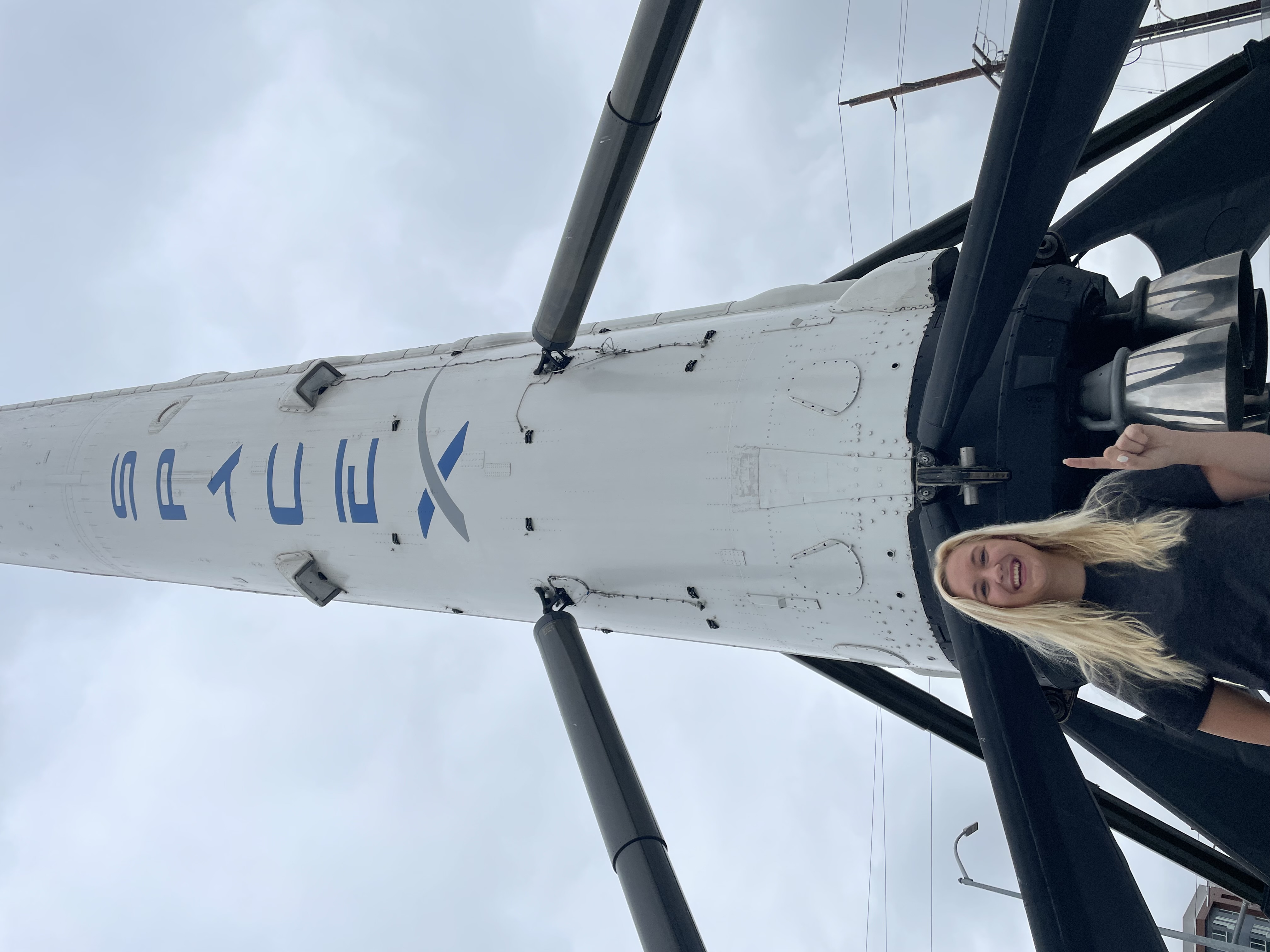Image of Stephanie at SpaceX HQ in front of a Falcon 9 rocket during her internship.