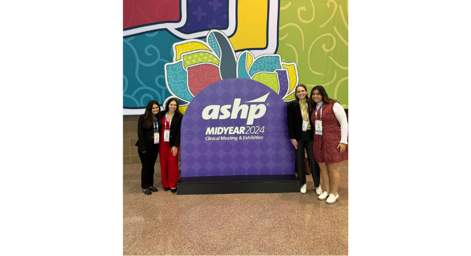 An image of Emily Taylor, Samantha Saraceno, Emma Atkinson, and Margaret Virostek in front of the American Society of Health-System Pharmacists conference sign.