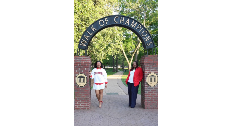 Image of Vernita and Le'Catherine Ivy leaning against the Walk of Champions entrance.