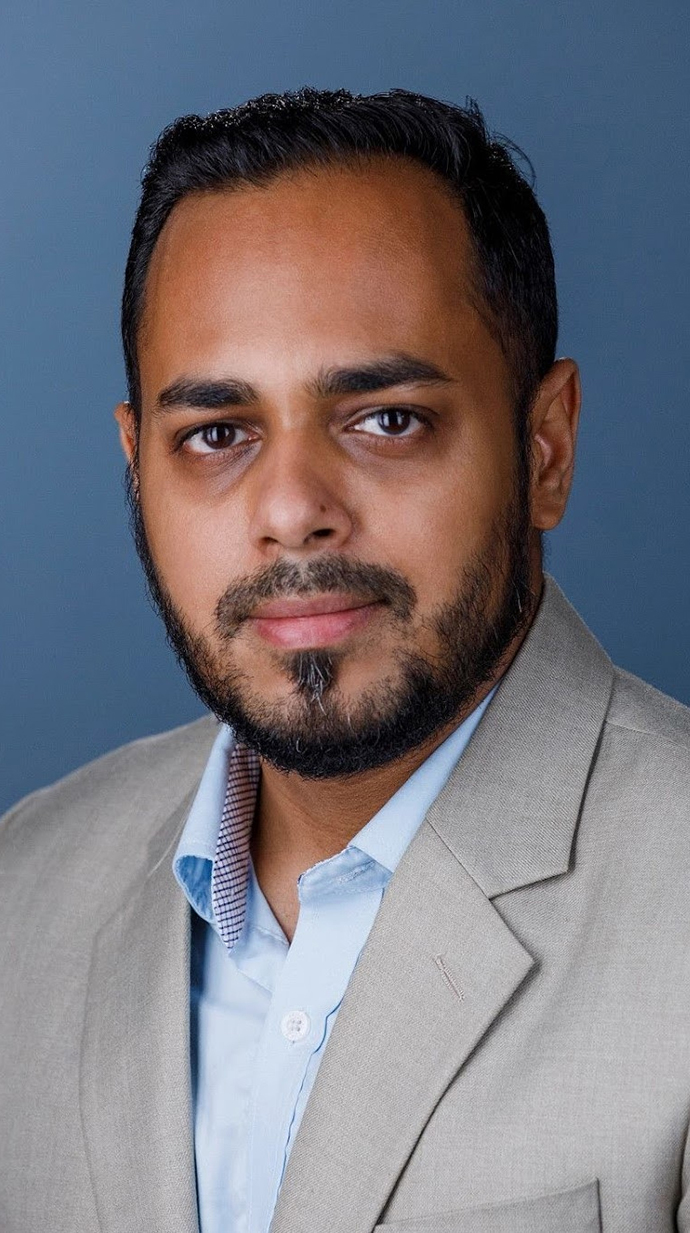 Headshot of a man wearing a gray suit jacket.