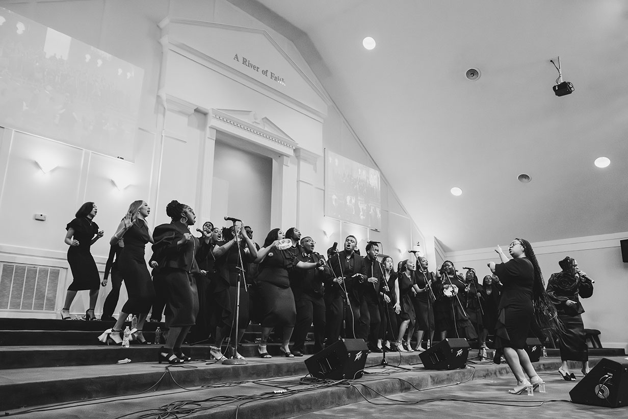 The University of Mississippi Gospel Choir performing on stage at Clear Creek Missionary Baptist Church during their 50th anniversary spring concert.