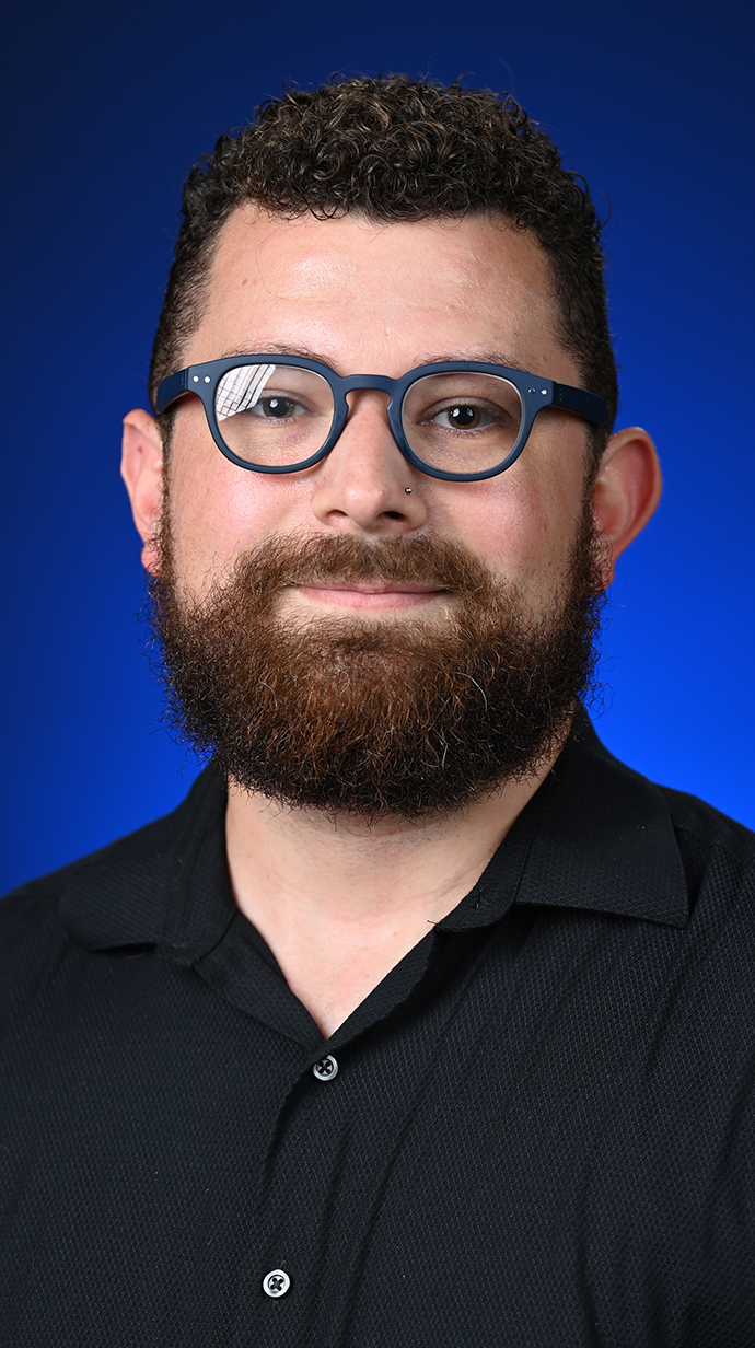 Head shot of a man wearing glasses and a black shirt.