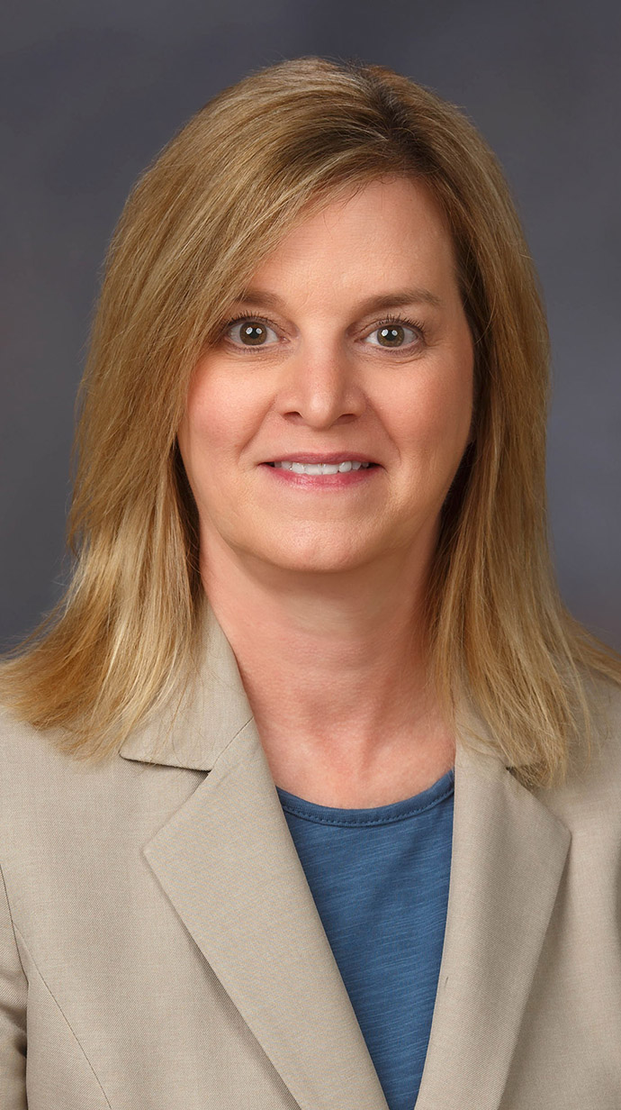 Head shot of a woman wearing professional attire.