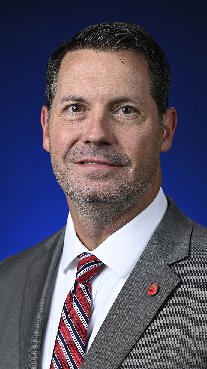 Headshot of a man wearing a suit.
