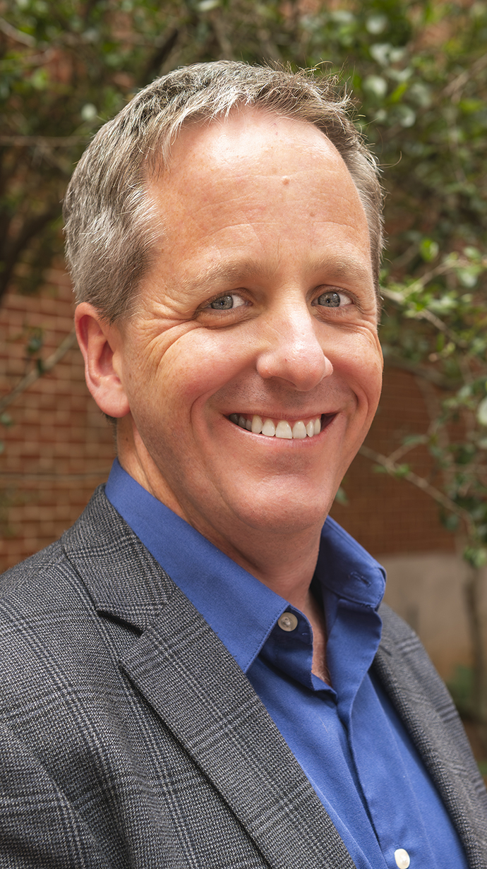 Headshot of a man wearing a suit jacket.