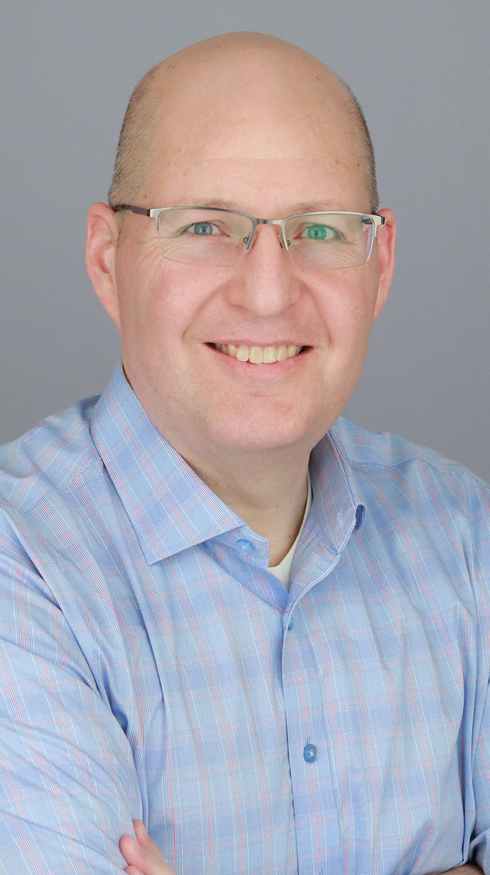 Headshot of a bald man wearing glasses.