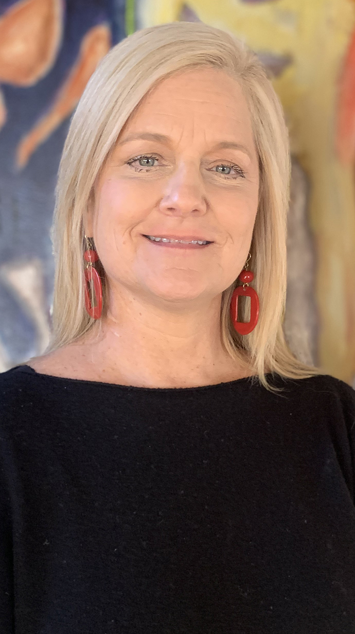 Headshot of a woman standing in front of colorful artwork