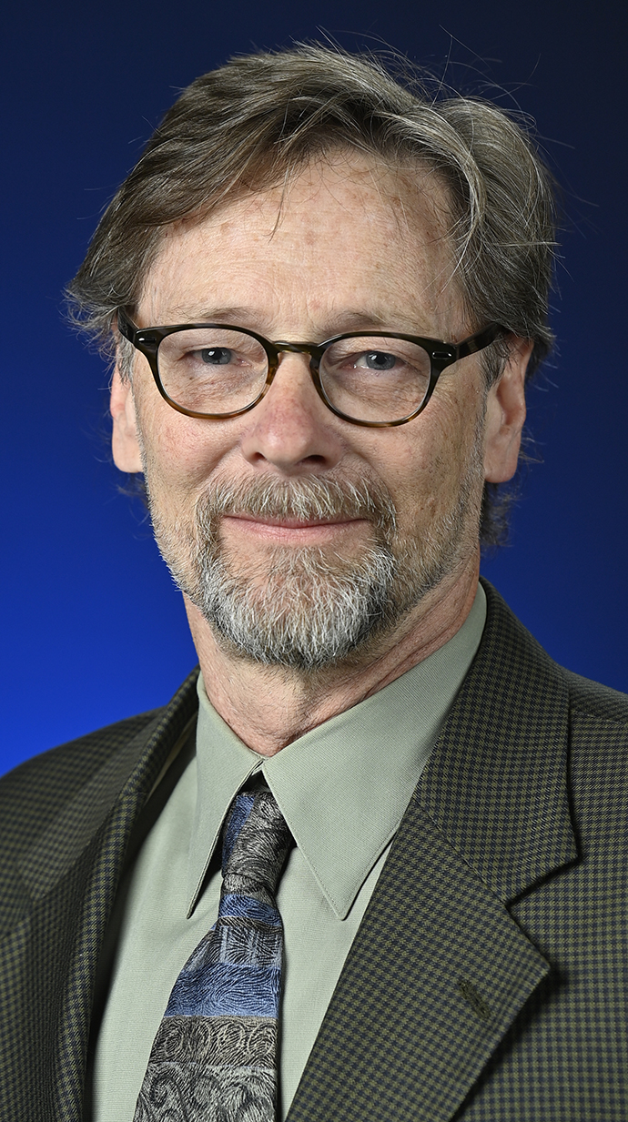 Headshot of a man wearing a coat and tie.