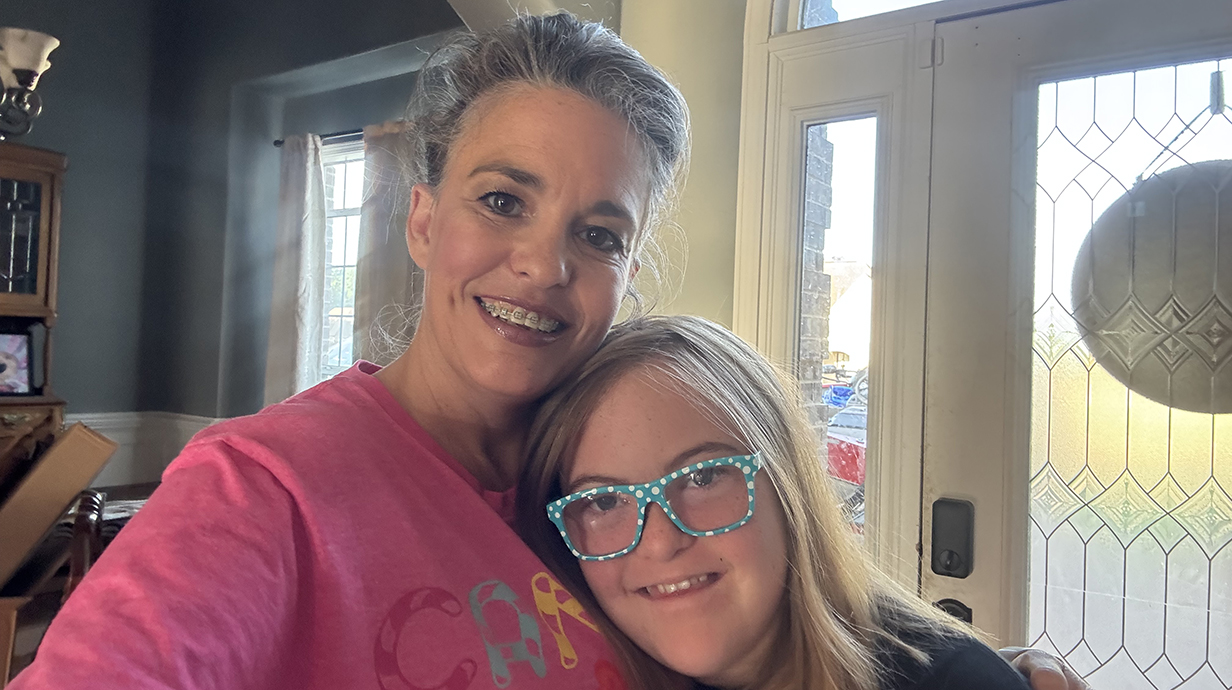 A woman and a young girl pose for a photo together.