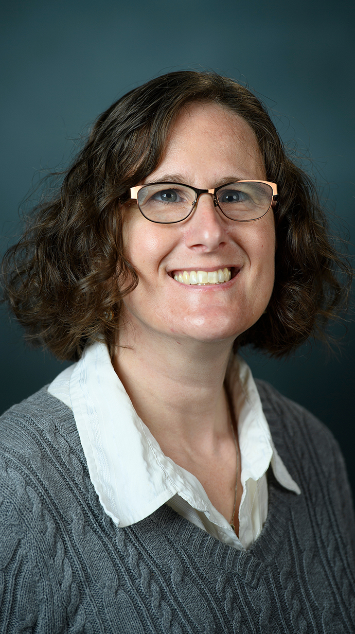 Headshot of a woman wearing a gray sweater.