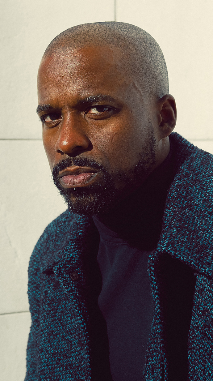 Headshot of a man wearing a blue jacket over a darker blue shirt.