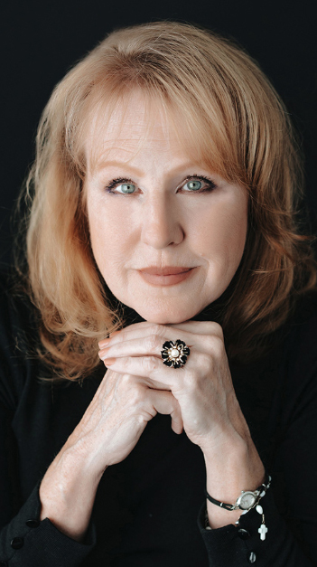 Portrait of a woman resting her face on ger hands.