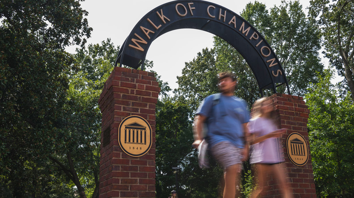 Students walk through the Walk of Champions gate on the University of Mississippi campus.