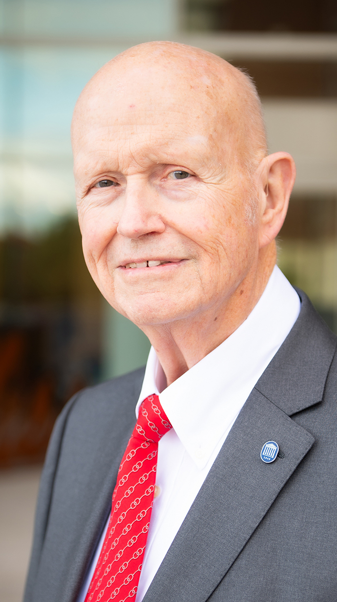 Headshot of a man wearing a dark suit.