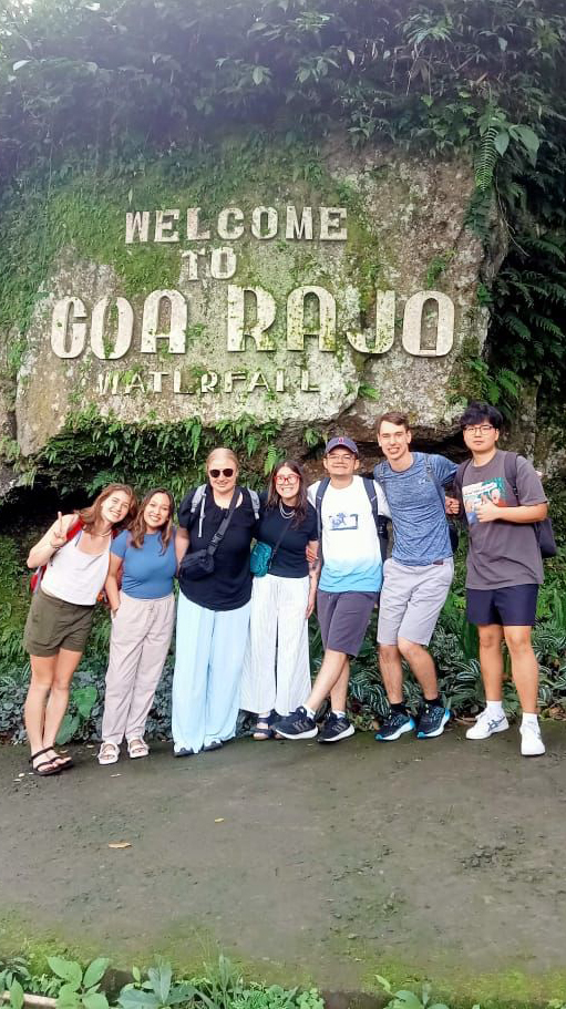 A group of young people visit a waterfall in bali.