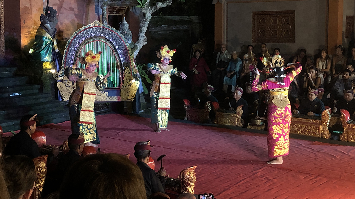 Several people in colorful attire perform an exotic dance.