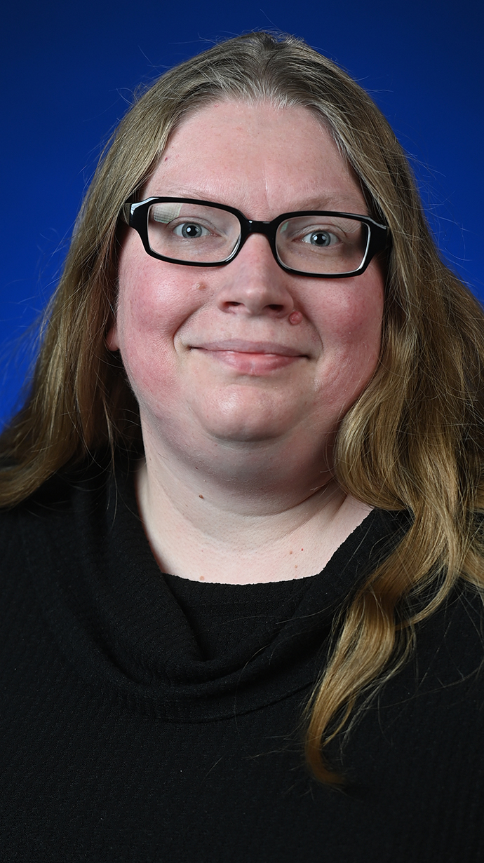 Headshot of a woman wearing glasses and a black top.