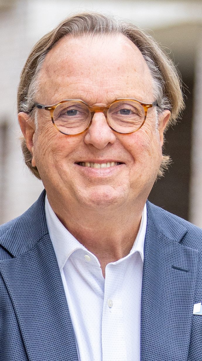 Headshot of a man wearing a blue sportcoat.