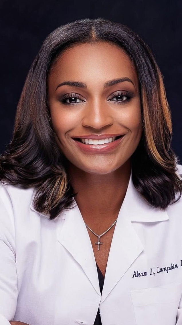 Headshot of a woman wearing a white medical coat.