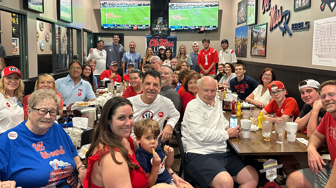 A large group of people attend a football watch party in a sports bar.