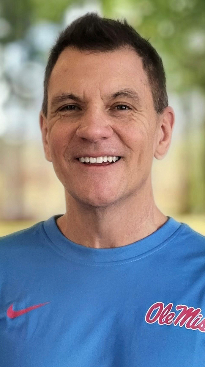 Headshot of a man wearing a light blue Ole Miss T-shirt.