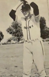 A young man prepares to throw a pitch in a vintage baseball photo.