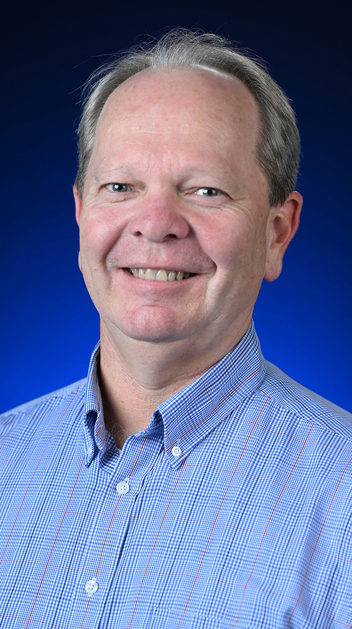 Headshot of a man wearing a light blue shirt.