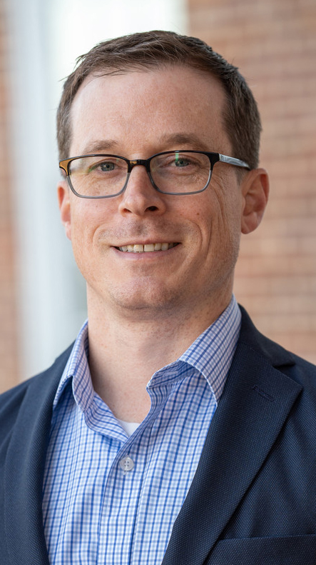Headshot of a man wearing a suit.
